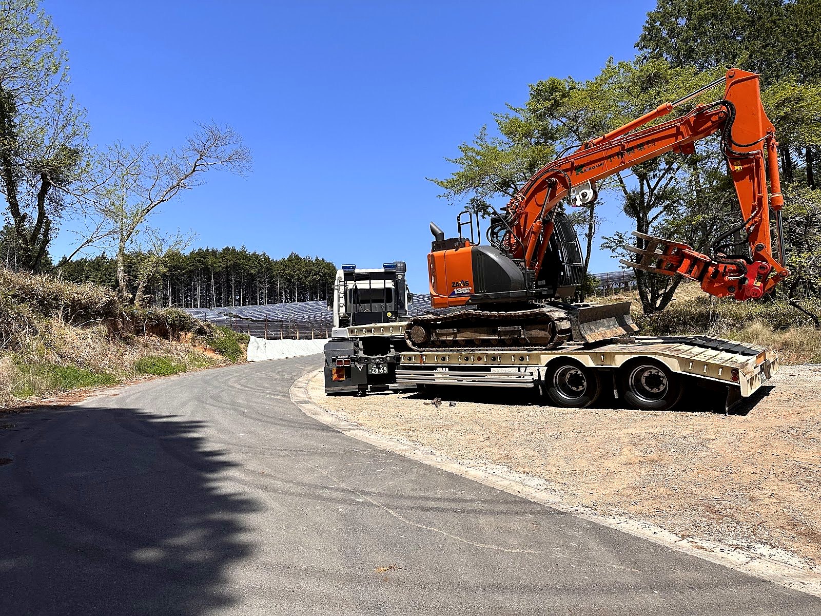 トレーラーで現場へ運ぶ自社の重機
